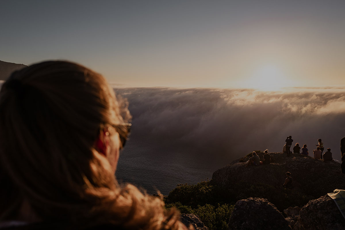 Woman looking out at sunset clouds